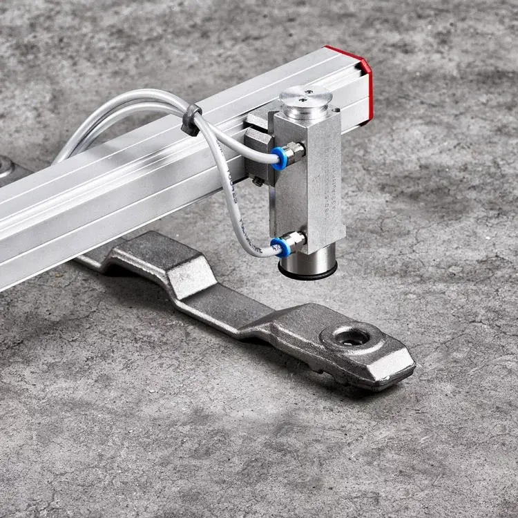 AGS magnetic gripper mounted on rail gripping a metal part on a concrete floor