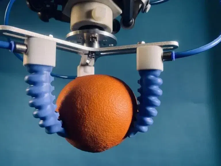 GorillaFinger robot end effector with five blue pneumatic soft gripper fingers holding an orange