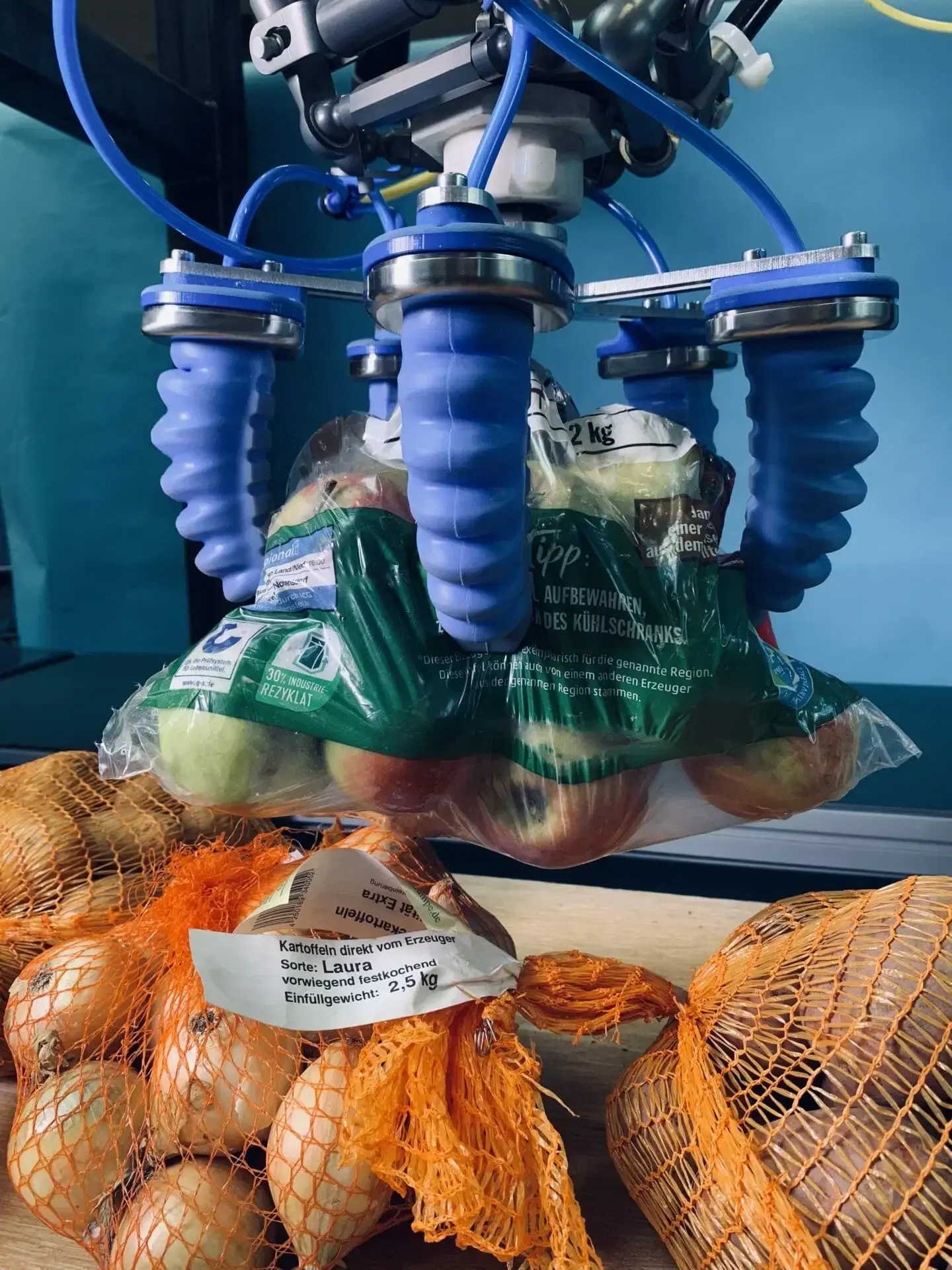 side view of pneumatic soft gripper holding a bag of apples