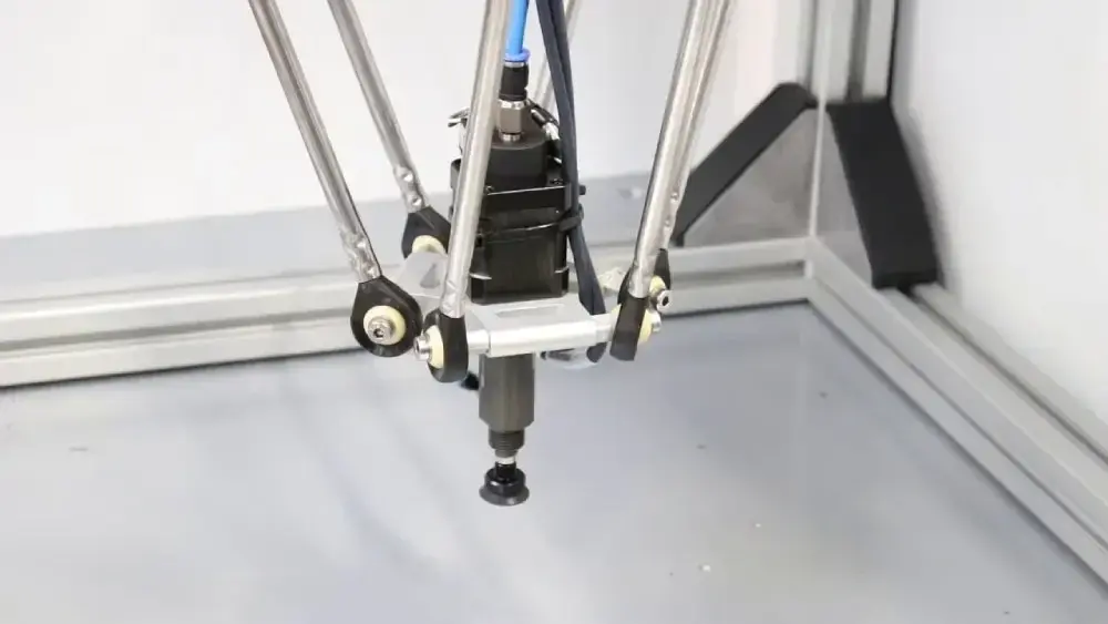 vacuum gripper mounted on a delta robot, holding a small object