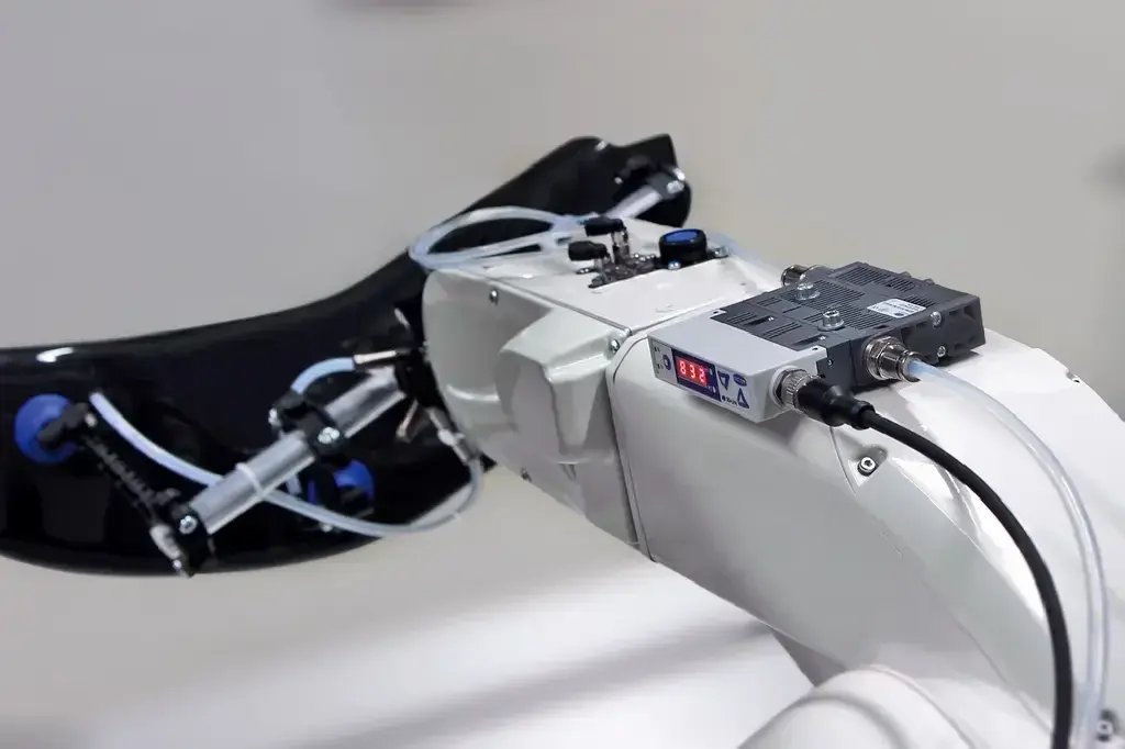Side view of Schmalz vacuum ejector mounted on a robotic arm with tubing connected