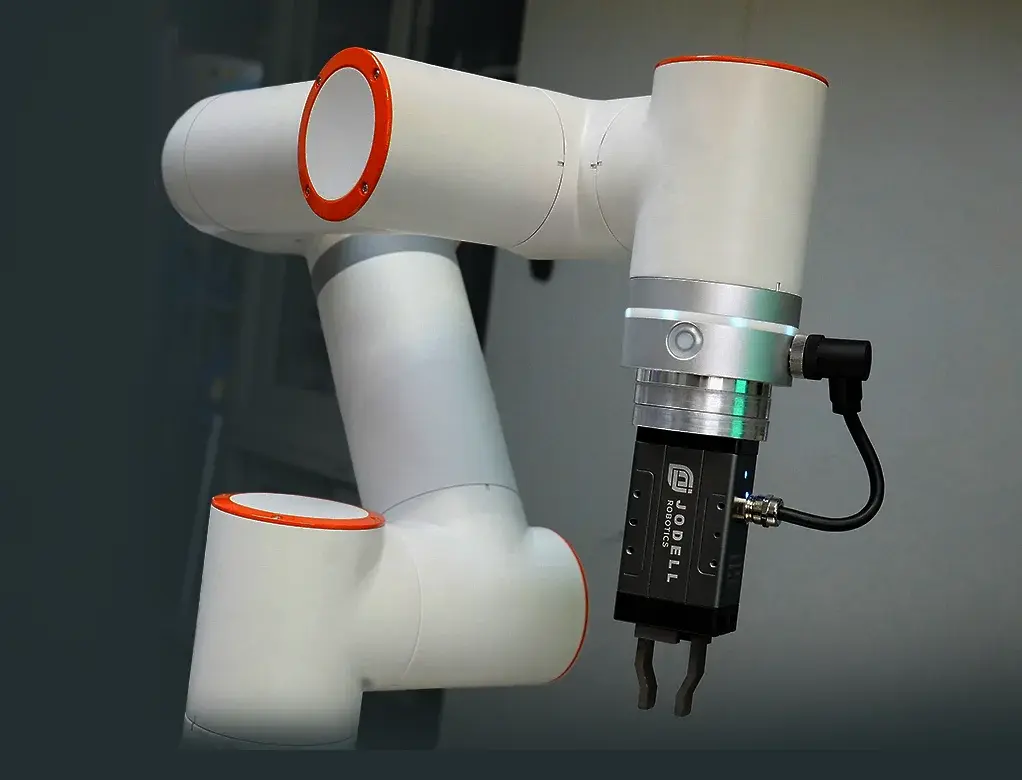 side view of white robotic arm with orange joint accents and black gripper attachment