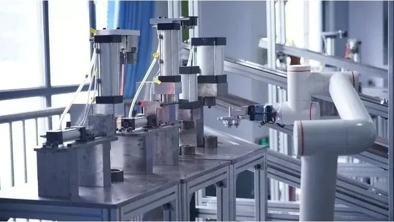 white collaborative robot arm with orange accents operating in an industrial setting