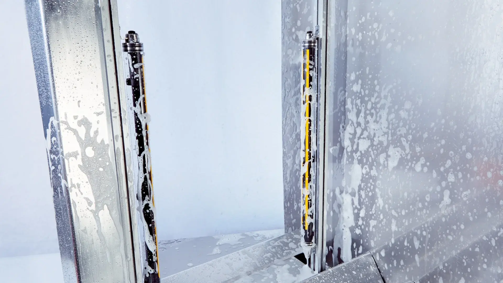 SICK deTec4 Core Safety Light Curtain mounted vertically inside a washing station with soap foam